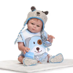 Detail of 48cm reborn doll with bear hat, cartoon bib, knit shoes, and feeding bottle