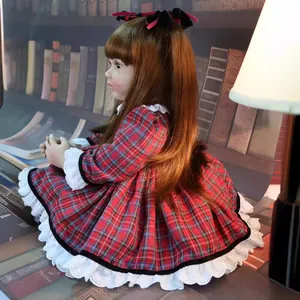 Reborn toddler doll 60cm with long brown hair and red plaid dress in cozy setting
