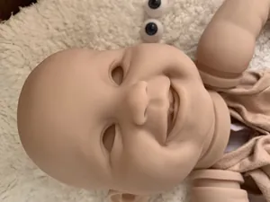 Detailed view of 22 inch reborn doll kit with smiling head mold and blue doll eyes