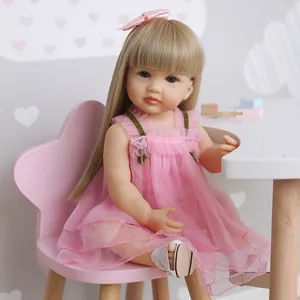 Poupée reborn fille 55cm avec cheveux blonds en robe de tulle rose assise sur chaise
