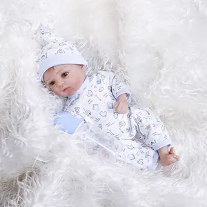 30cm lifelike reborn baby doll in blue printed romper resting on white plush background