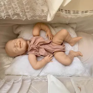 Lifelike unpainted reborn doll kit April in pink bodysuit on white plush bedding