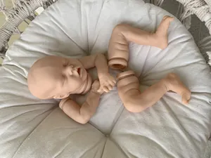 Detailed view of Twin A reborn doll kit with soft vinyl head and limbs in a cradle