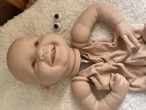 Macro view of 22-inch reborn doll kit featuring a realistic smiling head and vinyl limbs