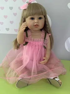 Detailed view of reborn toddler doll with blonde hair, blue eyes and pink mesh dress
