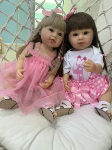 Macro detail of two realistic 55cm reborn toddler dolls in pink tulle and polka dot outfits