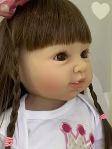 Detail of 55cm reborn toddler doll with brown hair, realistic eyelashes and crown outfit