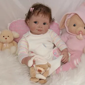 Realistic 22-inch reborn baby doll with blue eyes and brown curly hair on plush carpet