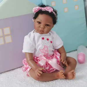 Poupée Reborn afro-américaine réaliste vêtue d'une tenue à pois rose et blanc