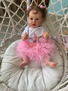 Close-up of silicone reborn doll in pink tutu and white star bodysuit in a cozy basket