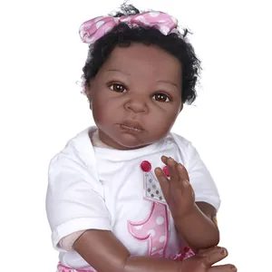 Poupée reborn noire réaliste avec bandeau à nœud rose et tenue de premier anniversaire