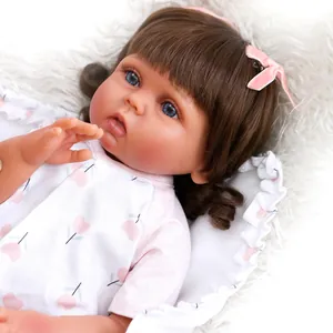 Close-up of lifelike reborn baby girl with brown hair and blue eyes on plush rug