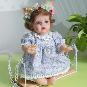 Poupée elfe reborn réaliste avec yeux bleus et bandeau floral sur balançoire blanche