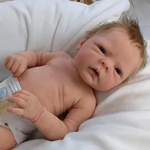 Close-up of realistic newborn reborn baby doll wearing a diaper on white fabric