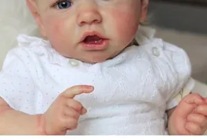 Macro view of lifelike reborn baby doll face with blue eyes and white lace dress