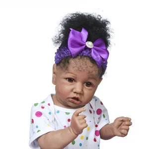 Poupée Reborn Saskia 55cm avec peau foncée cheveux bouclés noirs et tenue à pois arc-en-ciel