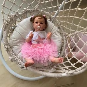 55cm Saskia reborn toddler doll in pink star outfit resting in a woven swing chair