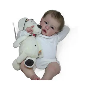 Lifelike 22-inch reborn baby girl doll in white lace outfit holding a plush puppy toy