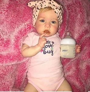 Gros plan d'une poupée reborn réaliste avec yeux bleus et vêtements de bébé roses