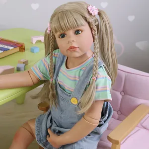 98cm life-size toddler doll with blonde hair sitting on a pink sofa in a play scene