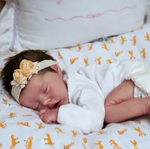 Realistic 18-inch sleeping reborn baby girl doll in white romper with lace headband