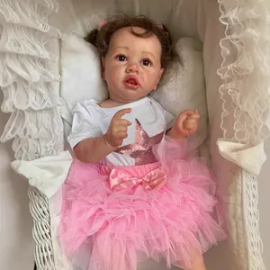 55cm Saskia reborn toddler doll in pink star outfit resting in a white lace bassinet