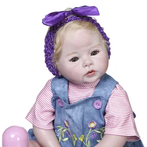 Poupée reborn réaliste 50cm avec cheveux blonds, bandeau mauve et robe en jean fleurie
