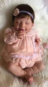Detailansicht der 22-Zoll Reborn-Puppe im rosa gepunkteten Kleid mit Blumen-Stirnband