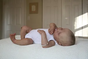 Détail d'une poupée reborn de 19 pouces endormie en body blanc avec bracelet en métal