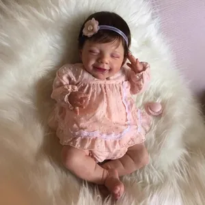 22-Zoll Reborn-Babypuppe mit rosa gepunktetem Spitzenkleid und Blumenstirnband auf Teppich