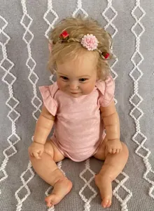 Detailed view of 60cm reborn toddler girl doll with curly hair in pink floral outfit