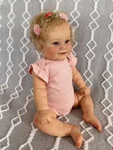 Detail of reborn toddler doll featuring curly blonde hair and pink floral headband