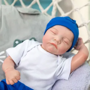 Realistic 19 inch sleeping reborn baby doll in blue outfit and hat on a cozy swing