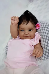 Dettaglio della bambola reborn Maddie nera da 50 cm con capelli ricci e fiore rosa