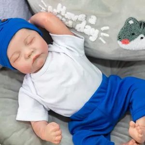 Realistic 19-inch sleeping reborn baby doll Levi wearing a blue knit hat and outfit