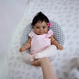 Bambola Reborn Realistica in Silicone Morbido Corpo in Cotone Tonalità Pelle Scura Giocattolo con Vestito Rosa Cuscino a Pois