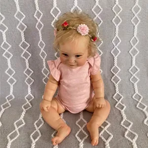 Realistic 60cm reborn toddler doll with blonde curls and pink floral outfit on knit blanket