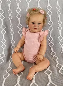 Realistic 60cm reborn toddler doll wearing a pink ruffled romper and floral headband