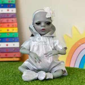 Cute 38cm alien reborn doll in silver metallic outfit sitting on green grass