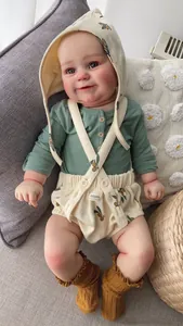 Close-up of lifelike 60cm reborn toddler doll wearing olive print romper and knit socks