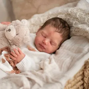 Lifelike 20 inch reborn doll kit Viviana sleeping in a cozy basket with a plush bear