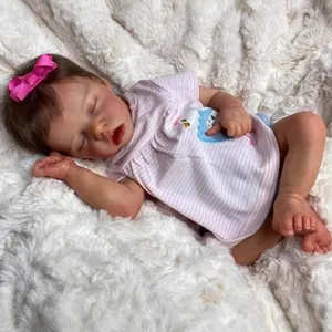 Realistic 18-inch reborn baby doll sleeping on white plush blanket in pink striped outfit