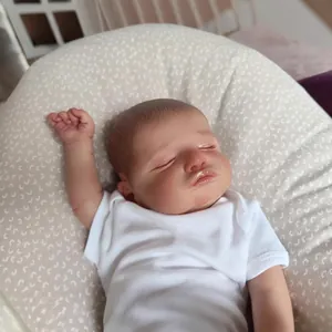 Realistic 48cm Rosalie reborn baby doll sleeping on floral pillow in white cotton bodysuit