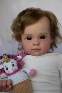 Detailed view of 60cm reborn baby doll Maggi with brown curls and soft cotton outfit