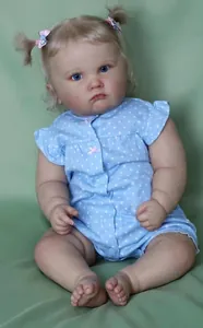 Close-up of a 60cm reborn baby doll with blonde hair, blue eyes and blue polka dot outfit
