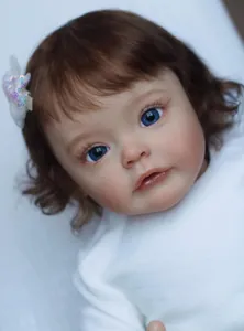 Close-up of 60cm reborn toddler doll with curly brown hair and lifelike facial details