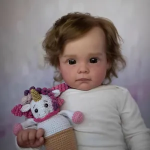 Realistic 60cm reborn doll Maggi with brown curls holding a crochet unicorn toy