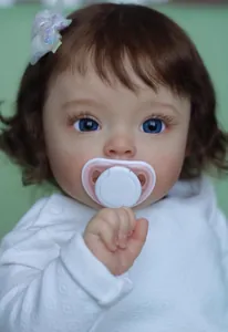 Close-up of a lifelike 60cm reborn doll with blue eyes, brown hair and a pacifier