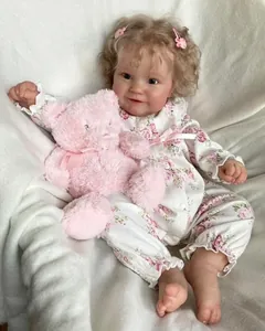 Close-up of lifelike Reborn Doll Maddie with curly hair and pink floral romper