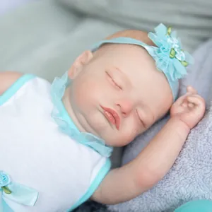 Poupée reborn réaliste Rosalie endormie avec bandeau en dentelle bleue sur peluche douce